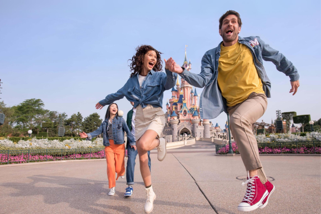 Ragazzi in gruppo saltano e gioiscono davanti al Castello a Disneyland Paris